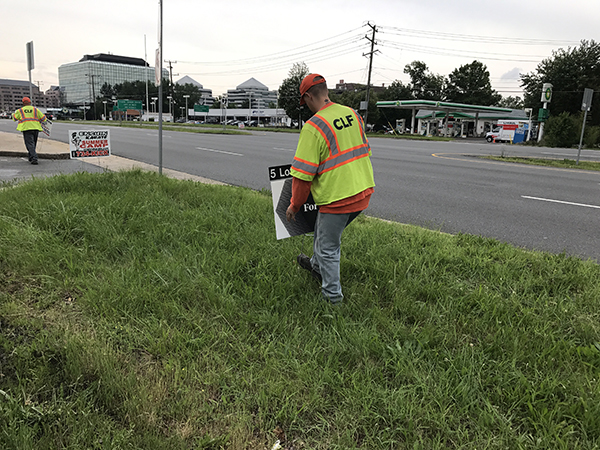 Community Labor Force workers picking up illegal signs