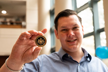 graduate of drug docket holds graduation coin