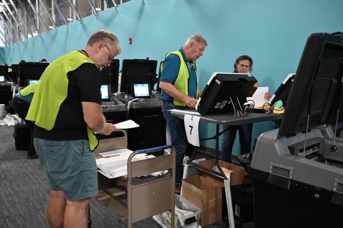 Image of election officers operating a ballot scanner. 