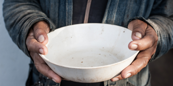 Person who is homeless with empty food bowl