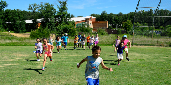 Children running in field at summer camp