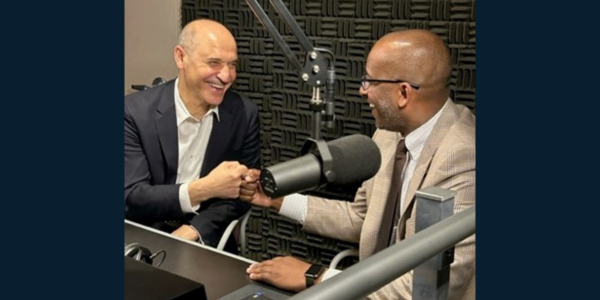 Victor Hoskins and Bryan Hill fistbumping during a podcast episode. 