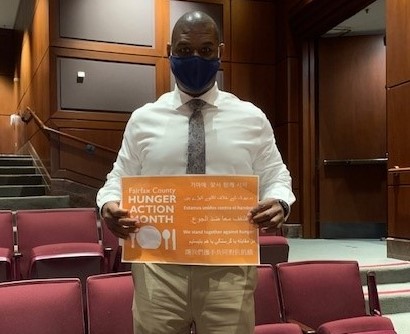 county employee holding hunger action month sign