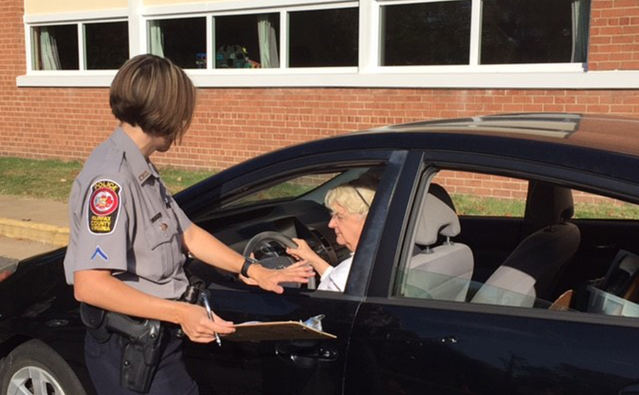 police officer assisting woman with CarFit program police officer assisting woman with CarFit program
