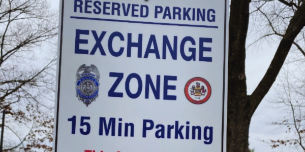 sign that reads "Reserved Parking, Exchange Zone" sign that reads "Reserved Parking, Exchange Zone"