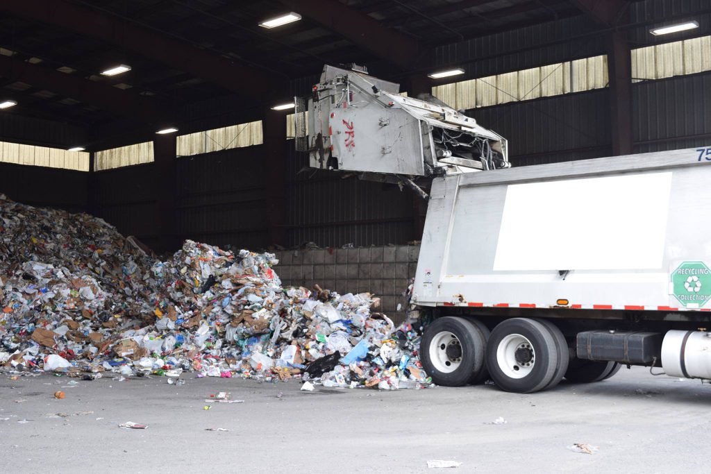 recycling truck emptying a collection bin in facility