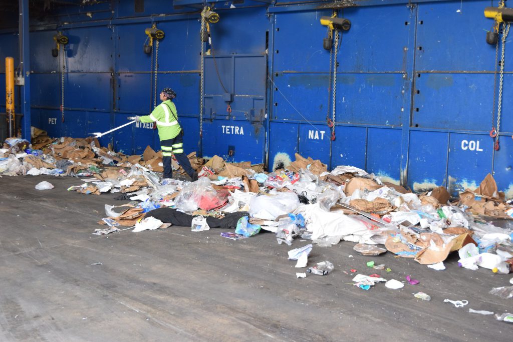 worker sorting through recycling materials in facility