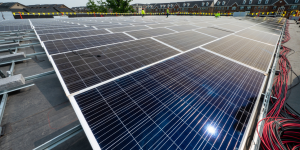 solar panels on the roof of the sully community center; a few workers are off in the distance