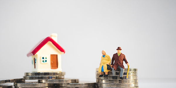 Photo of a house on a pile of coins.