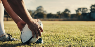 Player holding a rugby ball on a field