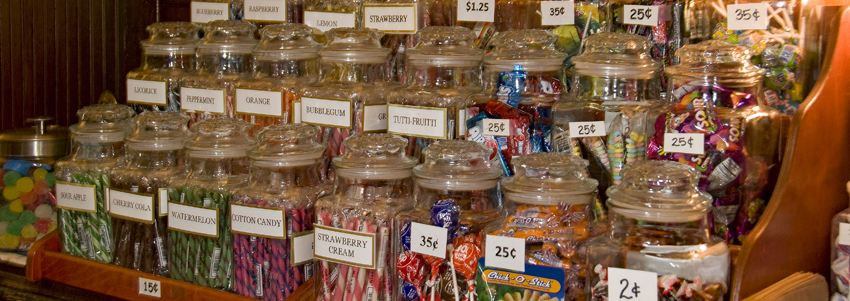 Penny candies in jars on a display rack