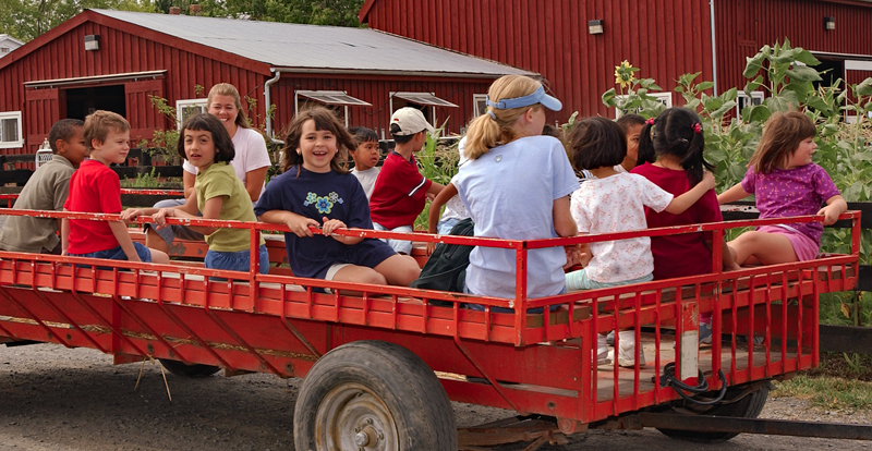People enjoying a wagon ride through the farm