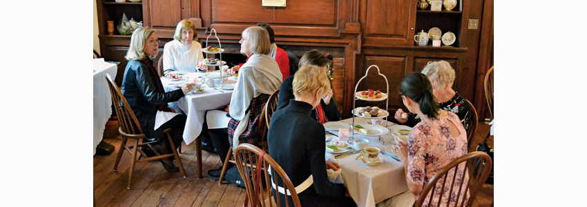 People gathered around tables at a formal tea