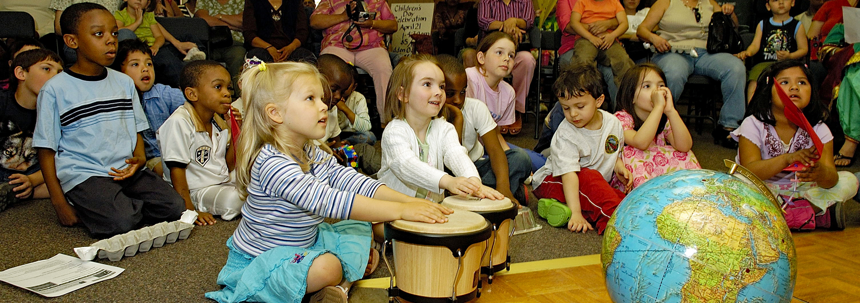 Several youngsters sit and listen to an instructor