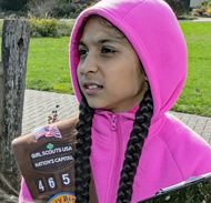 Young girl wearing Girl Scout sash