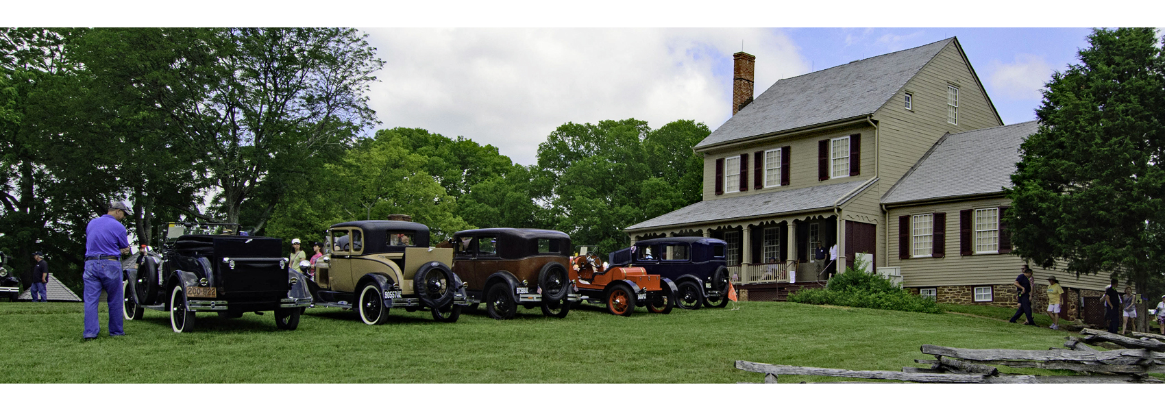 Several early 20th century cars lined up in front of Sully's historic house
