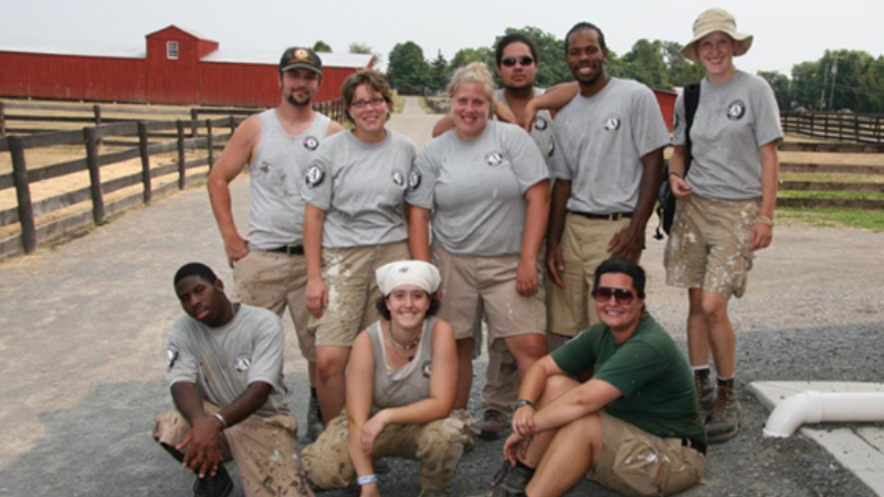 a group of volunteers in matching t-shirts standing in front of Kidwell Barn at the Fairfax County Park Authority Frying Pan Farm Park