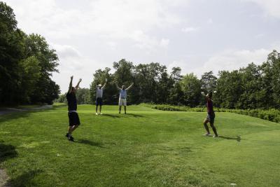 four people with their arms in the air, celebrating on a golf green at Twin Lakes