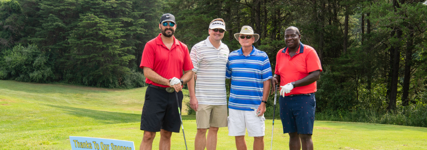 four golfers standing in front of the green, participating in the Duffer's Tournament