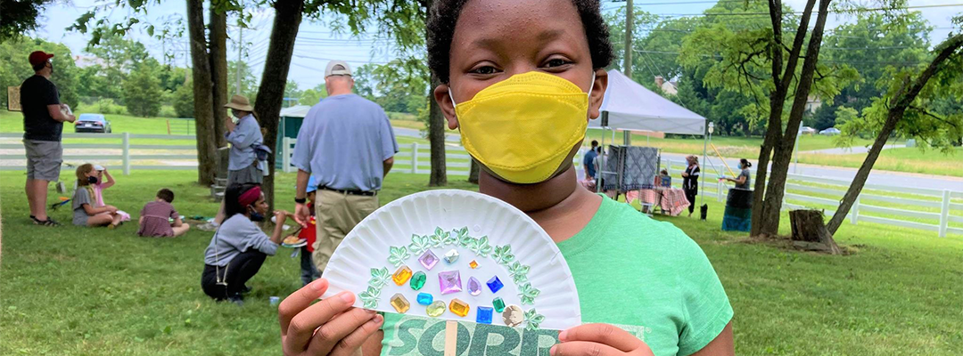 a child with a handmade fan on Juneteenth