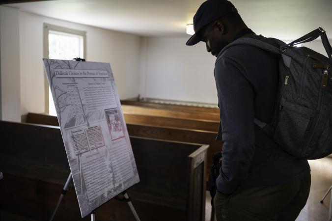 a man reads a sign at a Juneteenth event at Frying Pan Farm Park