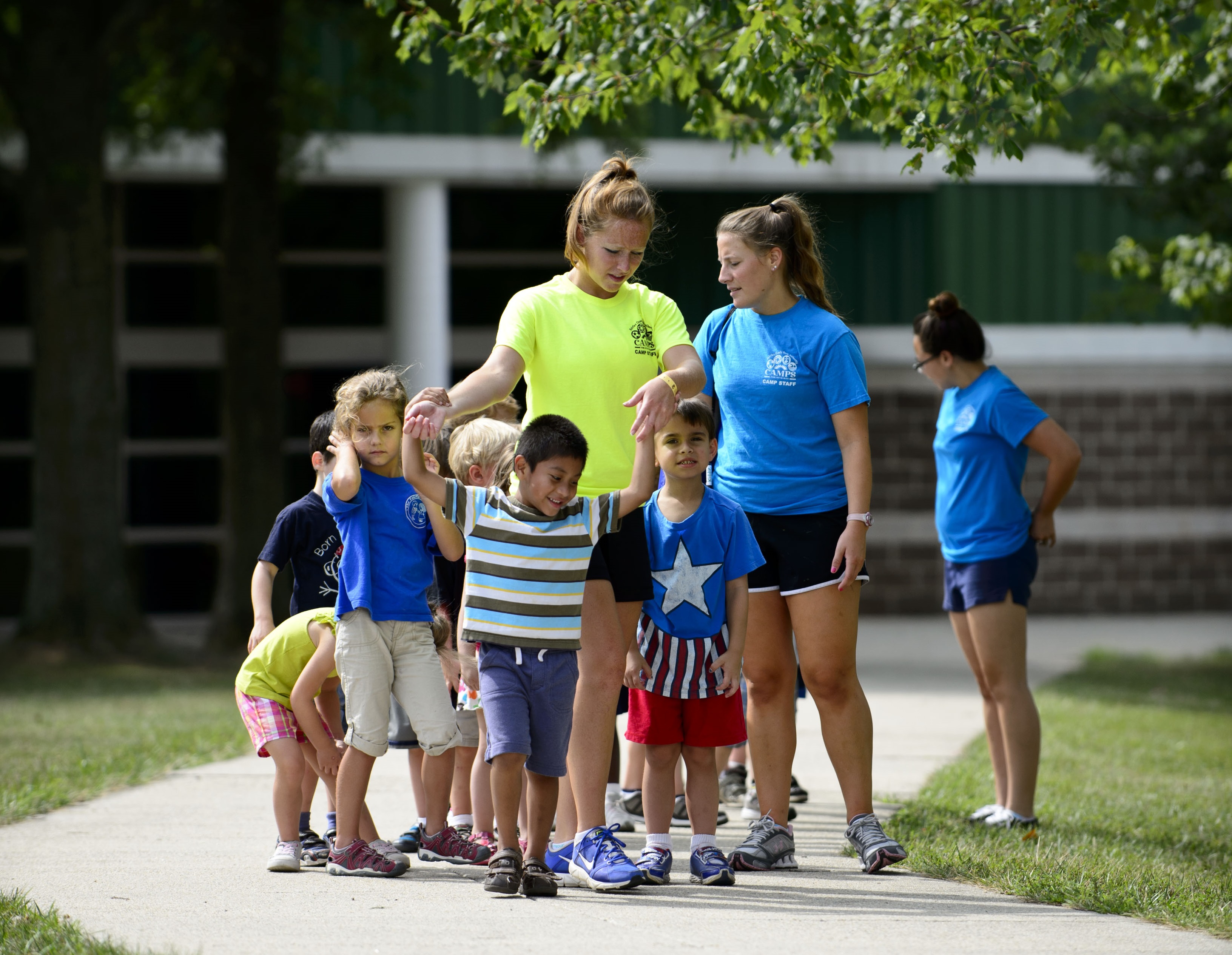 Camp counselor and campers walking down a path