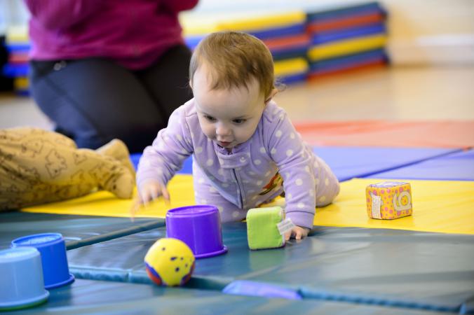 Infant crawling on a mat