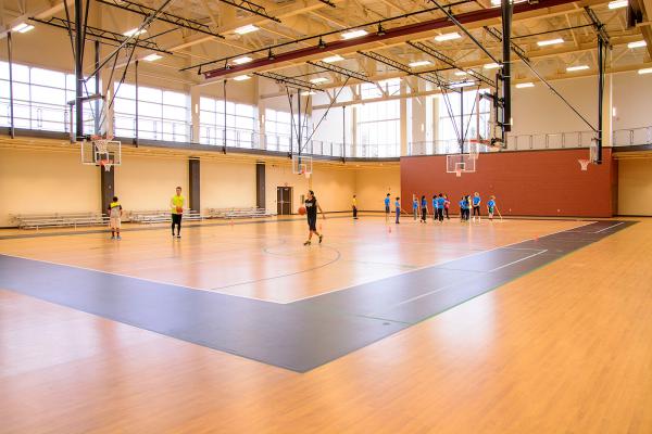 People playing basketball in gymnasium