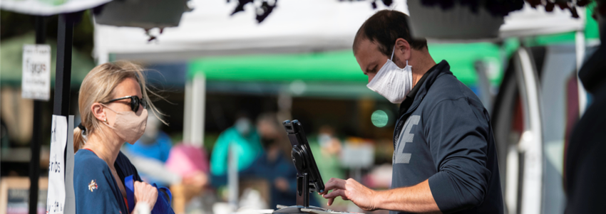 a vendor and customer at Mt. Vernon Farmers Market