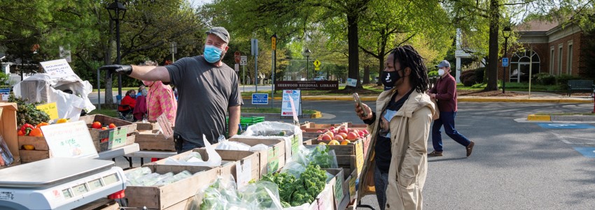 a vendor and customer at Mt. Vernon Farmers Market