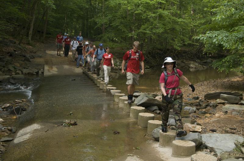 image of people walking through stream