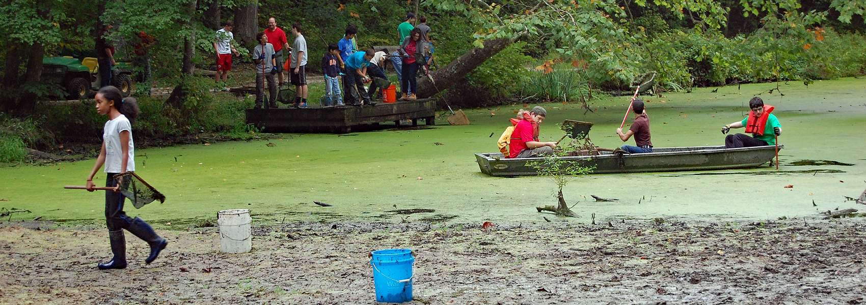 Teenagers clean duckweed from Hidden Pond