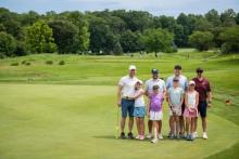 adults and kids on golf course