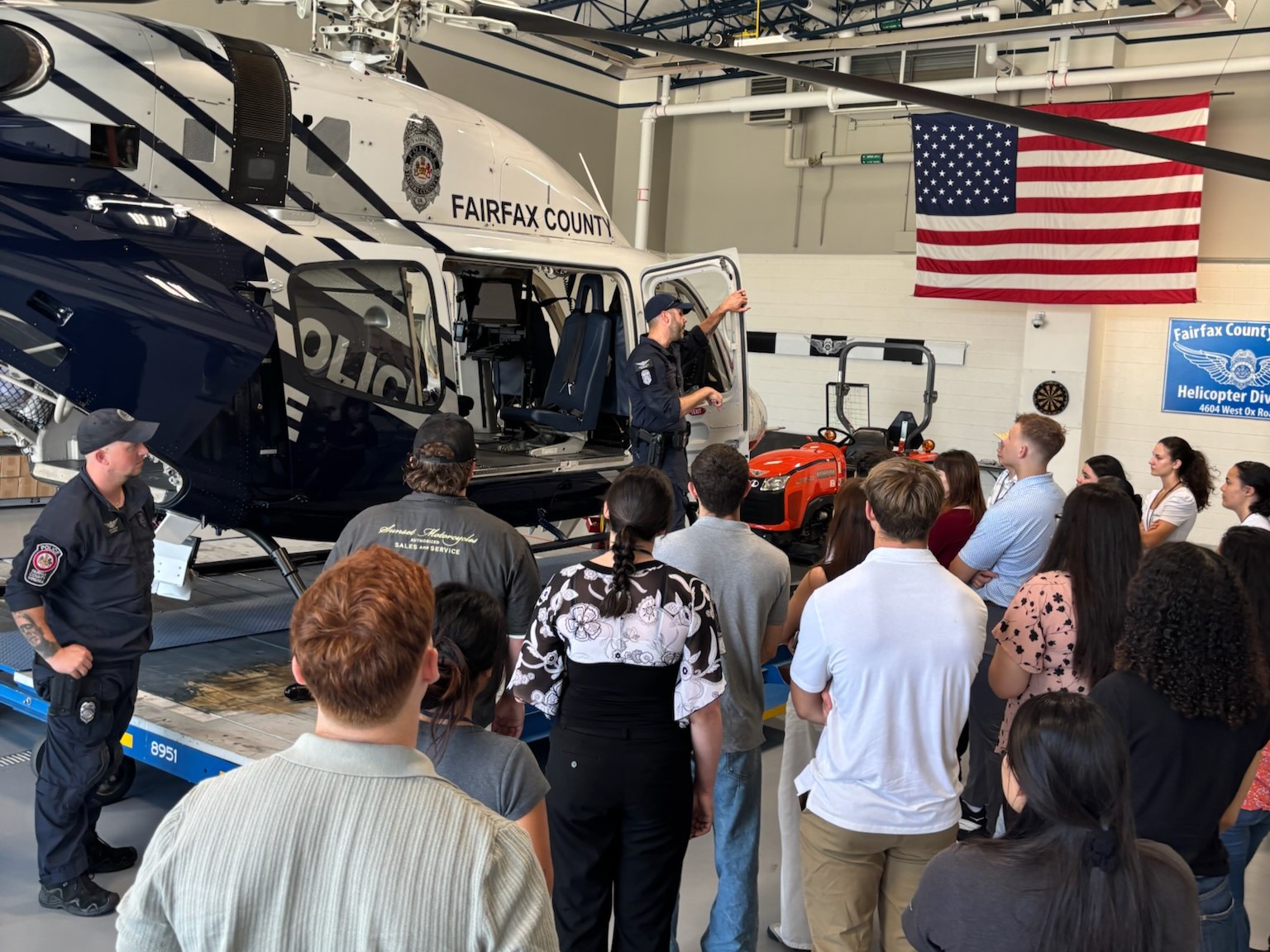 K9 officer and their working dog presents information outdoors to teens