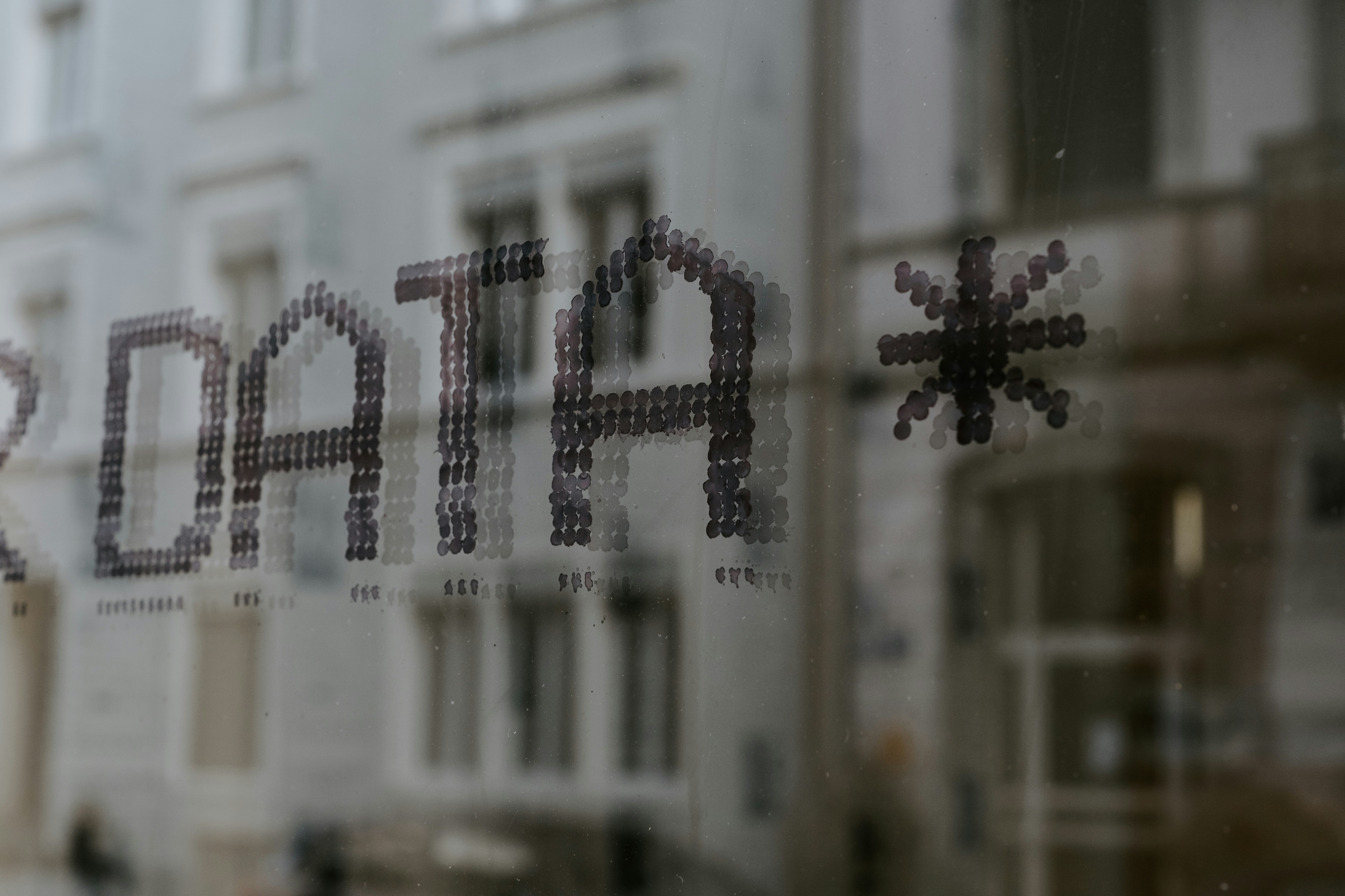 close up with data printed on window with buildings in the glass reflection