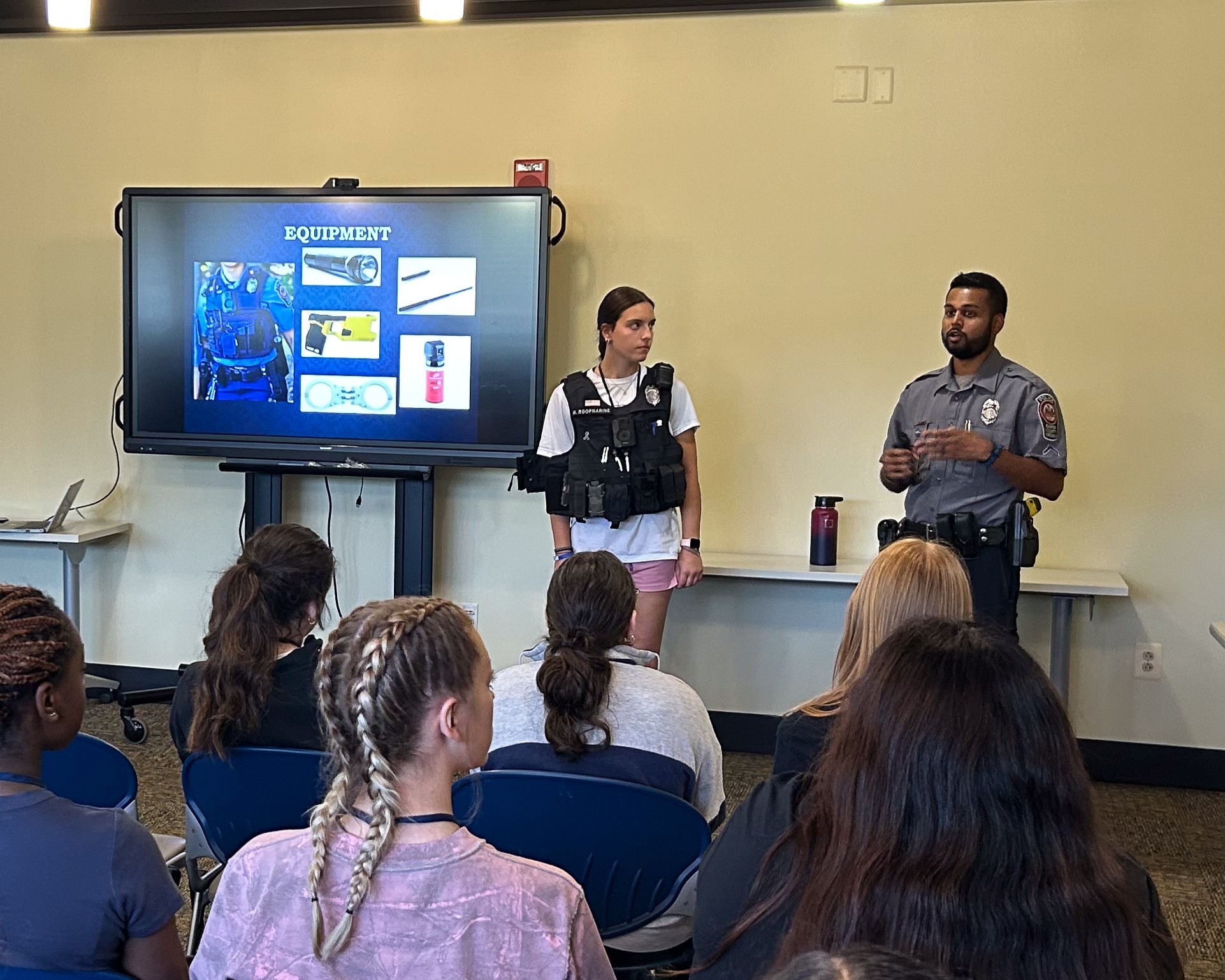 officer presenting to the class with participant at front with police gear