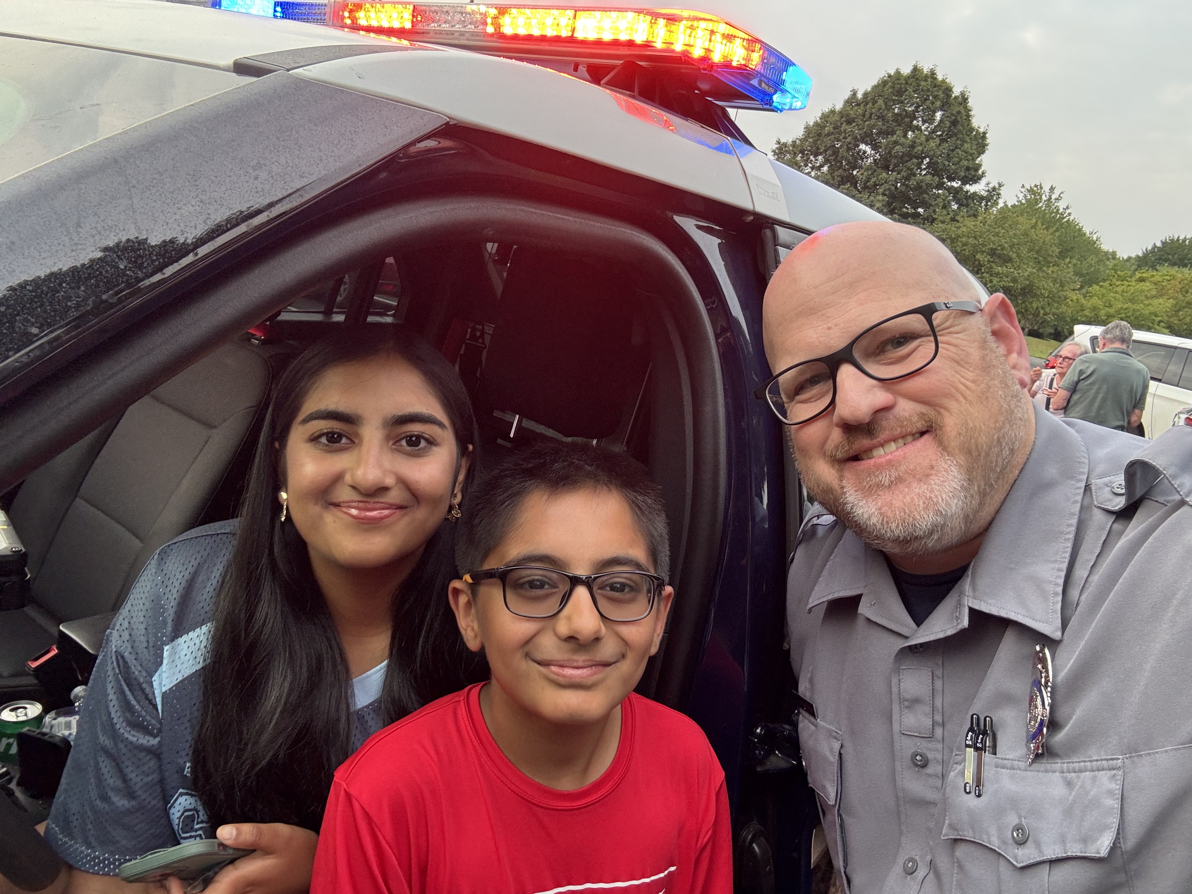 two kids and a community officer smiling
