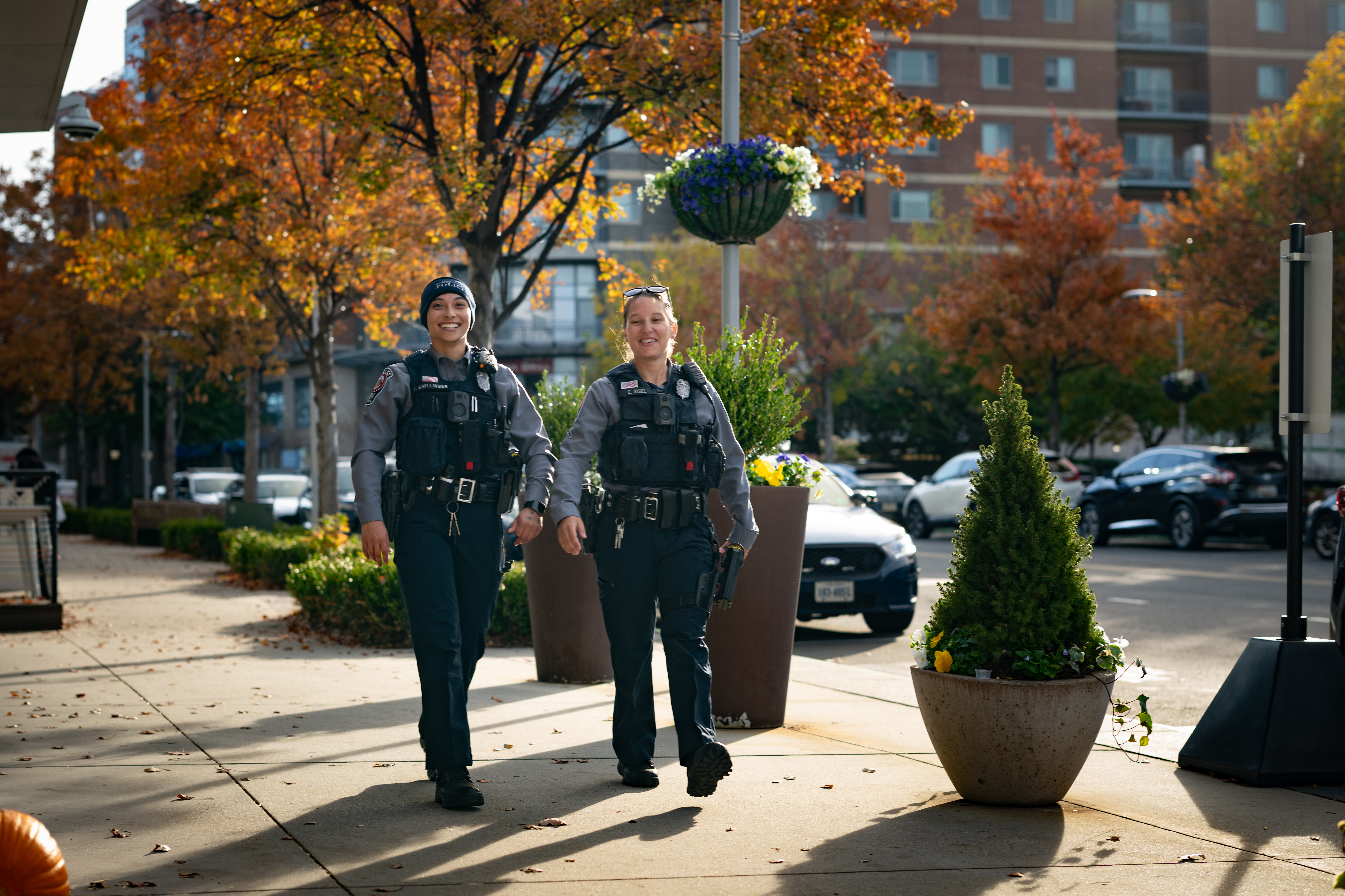 two female officers walking down a sidewalk street