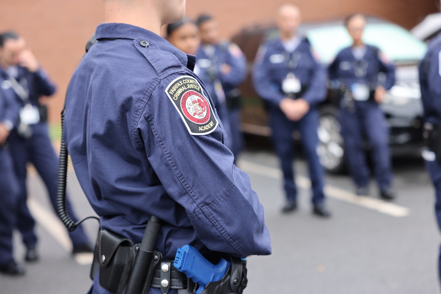 Side view of a recruit with a shoulder patch reading 'Fairfax County Criminal Justice Academy'