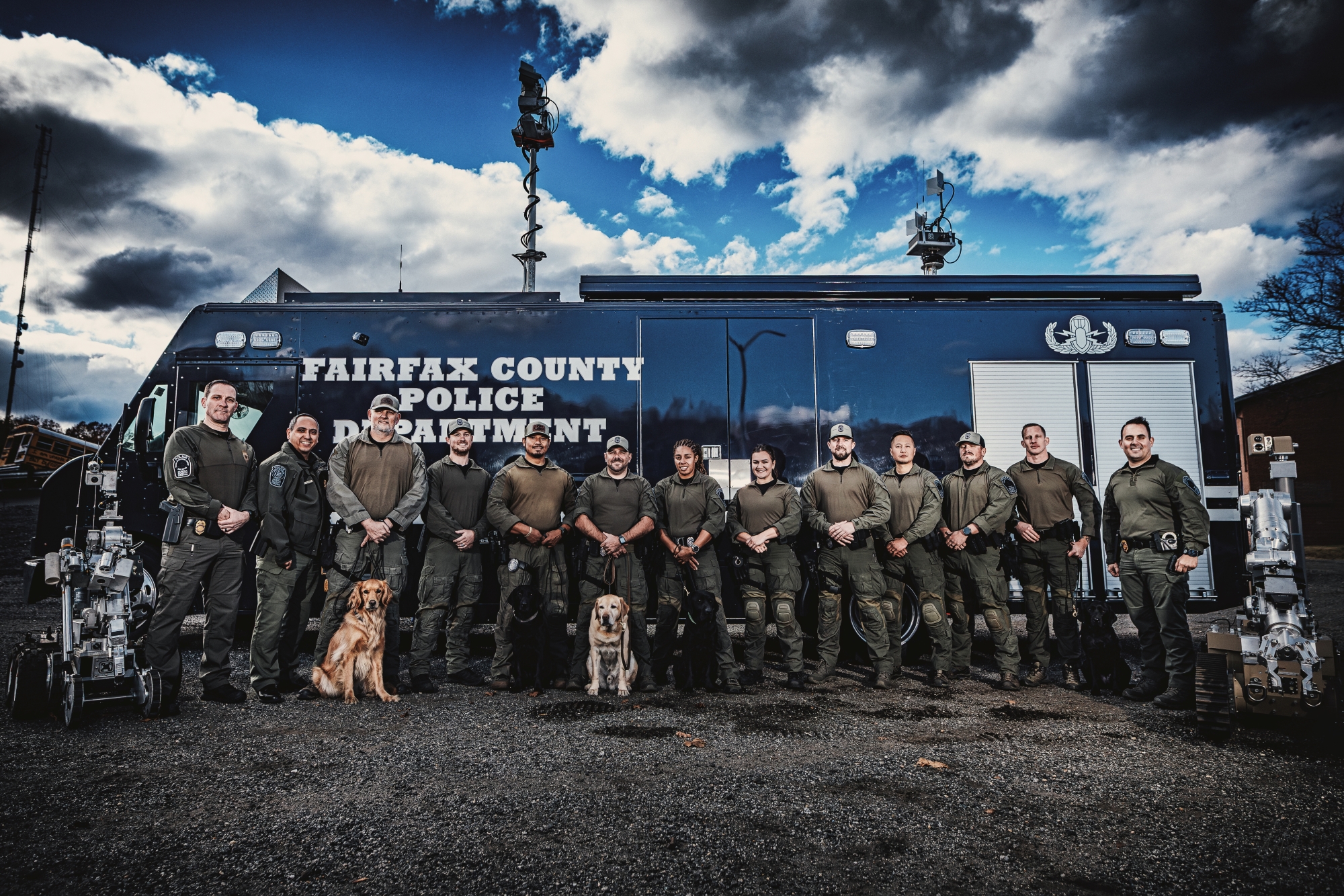 FCPD Explosive Ordnance Disposal team posed with detection dogs in front of the department's mobile command vehicle