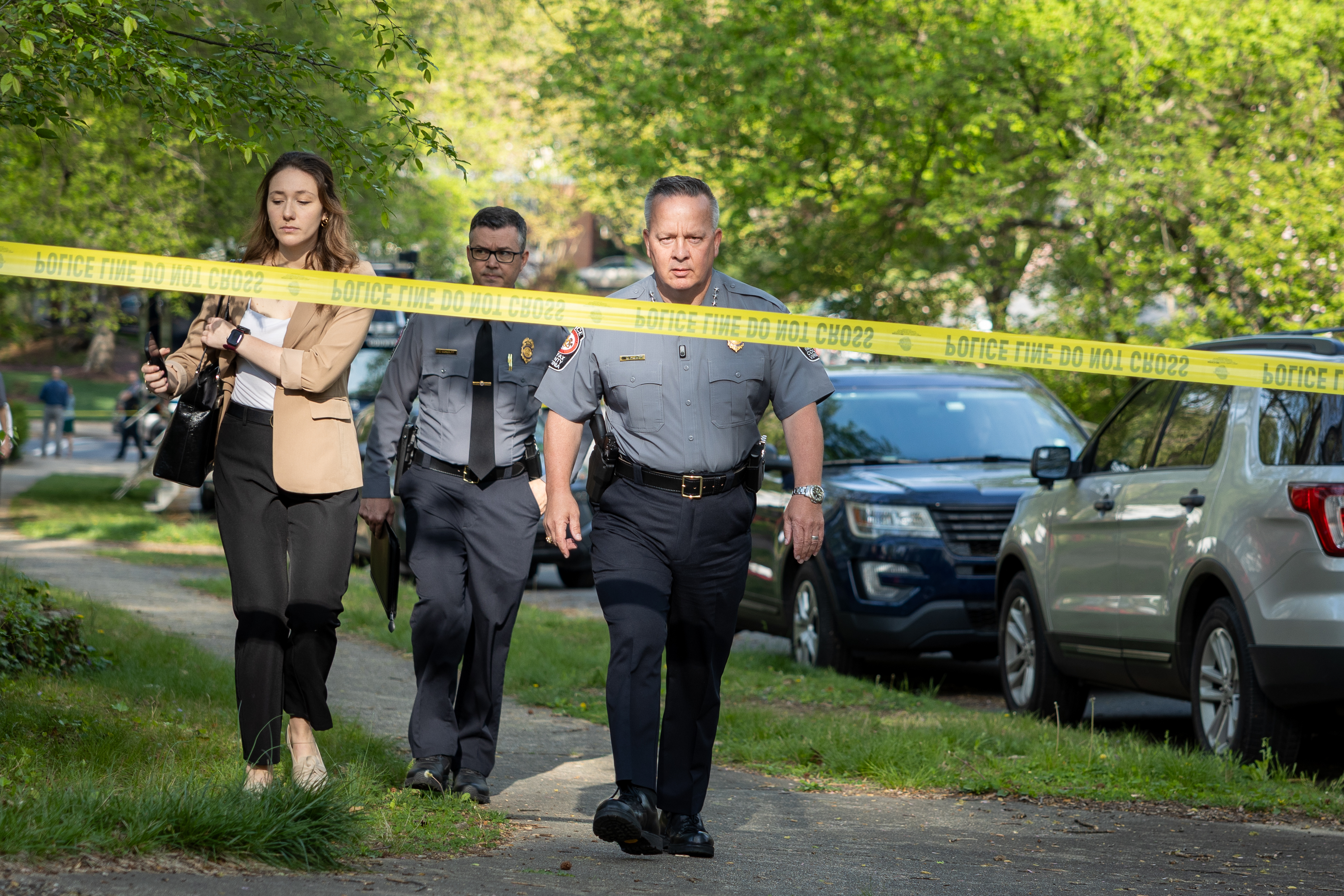 The public affairs director, public affairs captain, and police chief walking up to a crime scene