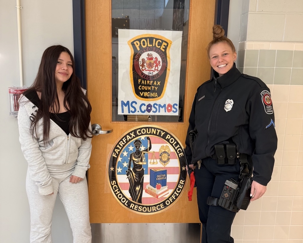 school resource officer with student, both smiling and standing in front of school resource officer door