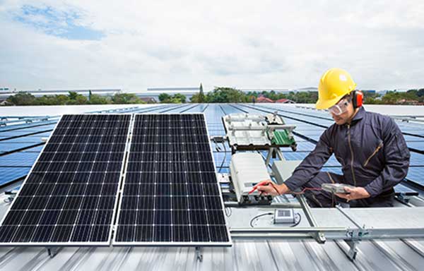 Solar panels being installed on the rooftop of a commerical building.