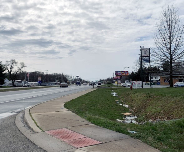 Trash blown into roadside ditch.