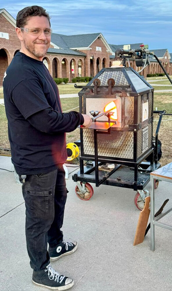 Participant blowing glass.