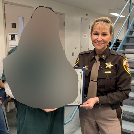 "John" receives his certificate from Sheriff Kincaid