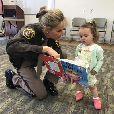 Sheriff Kincaid reads to little girl at library