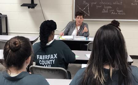 Volunteer speaks to inmates in classroom