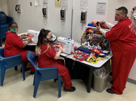 Three inmates, two sewing machines, many masks, fabric