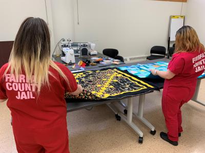 Two female inmates with the quilts they made